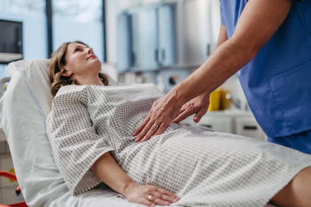 Doctor Palpating Womans Abdomen