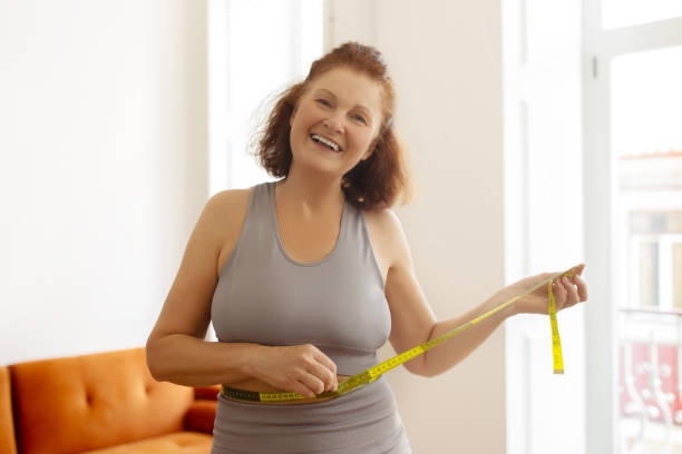 Happy Senior Woman Measuring Her