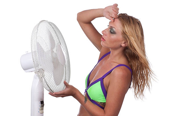 Woman Cools Down With Fan